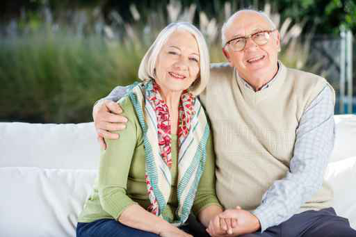 Happy Senior Man Sitting With Arm Around Woman On Couch Design